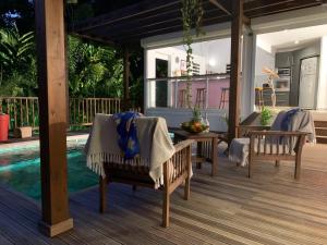 a patio with chairs and a table and a pool at VILLA CAZARAMEL in Le Gosier