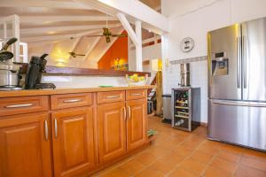 cocina con armarios de madera y nevera de acero inoxidable en Villa LALALAND, en Le Gosier