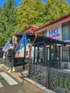 a building with two flags in front of it at Hotel Gâlma in Moroeni