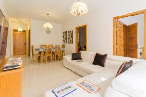 uma sala de estar com um sofá branco e uma mesa em Cotswold Sea Apart with 3 bdr at Qawra - Happy Rentals em St. Paul's Bay