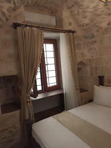een slaapkamer met 2 bedden en een raam bij CARRA KONAĞI in Mardin