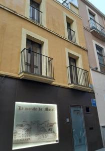 Un edificio con un cartel al costado. en La Morada de Moret, en Cáceres