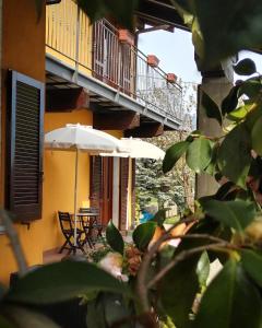 a patio with two tables and an umbrella and chairs at In campagna in Besozzo