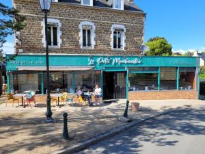 a building with a restaurant with tables and chairs at Le petit Montmartre in Dinard