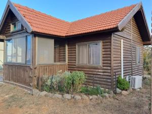 a log cabin with an orange roof at בקתות קסם חרמון in Nimrod