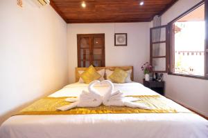 two swans towels on a bed in a room at Dear Villa House in Luang Prabang +21 photos