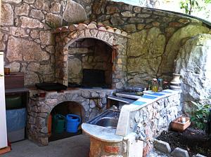 uma cozinha de pedra com um forno de pedra e um lavatório em Villa Rose Apartment em Lovran