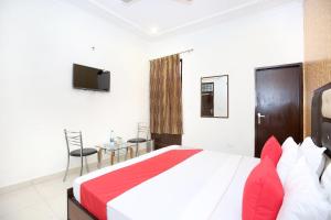a bedroom with a large bed and a table at OYO Flagship Hotel Adarsh in Chandīgarh