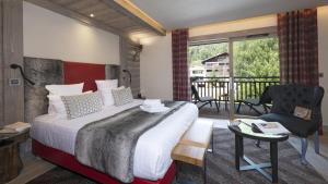 a hotel room with a bed and a balcony at Hôtel Alexane in Samoëns