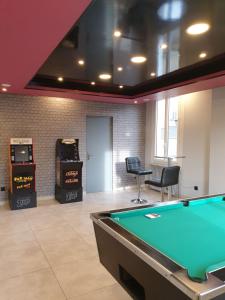 a room with a pool table and two arcade machines at Loc'citanie chambres double in Aussillon