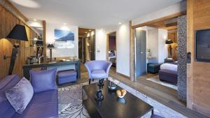 a living room with a purple couch and a bedroom at Hôtel Alexane in Samoëns