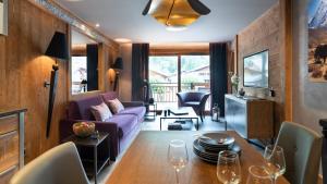 a living room with a purple couch and a table at Hôtel Alexane in Samoëns