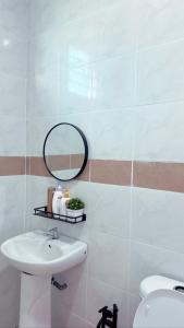 Easy Homestay في Mukah: حمام مع حوض ومرآة على الحائط