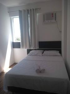 een slaapkamer met een wit bed en 2 handdoeken bij Apto 3/4 Mobiliado em Recife Cond. CLUBE in Recife