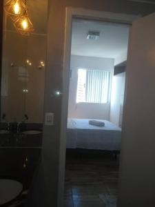 een slaapkamer met een bed en een badkamer met een raam bij Apto 3/4 Mobiliado em Recife Cond. CLUBE in Recife