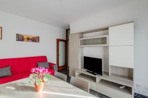 a living room with a red couch and a table at Zagar House-Venice Airport Close-by Apt W Parking in Campalto