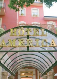 un panneau indiquant l'entrée de l'hôtel devant un bâtiment dans l'établissement Hotel America, à Trente
