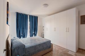 a bedroom with a bed and a window with blue curtains at Zagar House-Venice Airport Close-by Apt W Parking in Campalto
