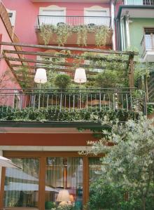 ein Gebäude mit einem Balkon mit Pflanzen in der Unterkunft Hotel America in Trient