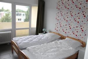 ein Schlafzimmer mit einem Bett mit Blumenwand in der Unterkunft Großzügige Ferienwohnung E328 an der Ostsee in Brasilien