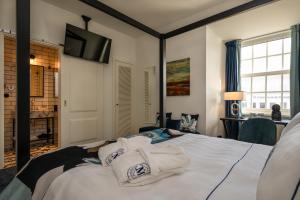 - une chambre avec un lit et des serviettes dans l'établissement Dona Maria Hotel, à Figueira da Foz