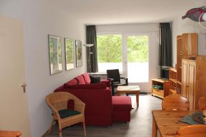 a living room with a red couch and a table at Ferienwohnung L217 für 2-4 Personen an der Ostsee in Brasilien