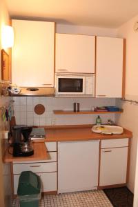 a kitchen with white cabinets and a microwave at Ferienwohnung L217 für 2-4 Personen an der Ostsee in Brasilien