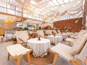 a restaurant with white tables and chairs and windows at Stellar GoldenHill Cameron in Tanah Rata