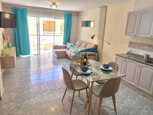 a kitchen and a living room with a table and chairs at Gold Oasis Apartment in El Médano