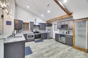 a large kitchen with wooden floors and stainless steel appliances at Whiskey Pines Retreat! Single Level Home, Outdoor Firepit, AC, BBQ! Sleeps 9 in Lake Harmony! in Lake Harmony
