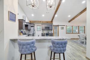 a kitchen with two blue bar stools at Whiskey Pines Retreat! Single Level Home, Outdoor Firepit, AC, BBQ! Sleeps 9 in Lake Harmony! in Lake Harmony