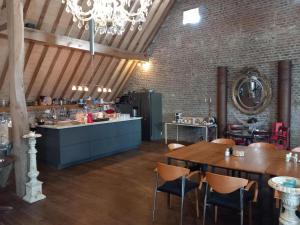 un ristorante con tavolo e sedie e una cucina di Ruim appartement voor 14 personen a Eijsden