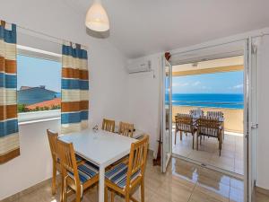 een eetkamer met een tafel en stoelen en de oceaan bij Apartments Cikač II - modern apartments by the beach in Mandre