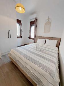 a large bed in a white bedroom with a light at Cueva Atlantis in Stamnoí