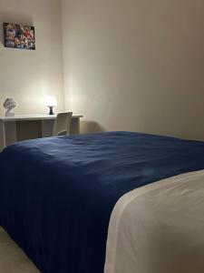 ein Schlafzimmer mit einem Bett mit einer blauen Decke in der Unterkunft Le radici dell’Etna holiday house in Paterno