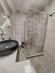 a bathroom with a shower and a black sink at Cueva Atlantis in Stamnoí