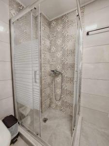 a shower with a glass door in a bathroom at Cueva Atlantis in Stamnoí
