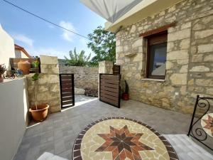 a courtyard with a stone building with a patio at Cueva Atlantis in Stamnoí