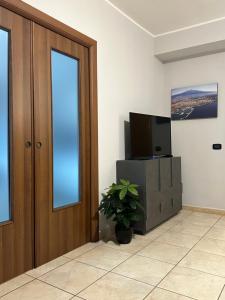 a room with a tv and a door and a plant at Le radici dell’Etna holiday house in Paterno