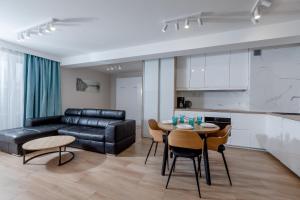 sala de estar con sofá de cuero negro y mesa en Resort Apartamenty Klifowa Rewal 50 en Rewal