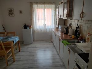 uma cozinha com um lavatório, uma mesa e uma janela em Apartmán U Kláštera em Broumov