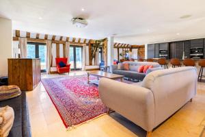 un soggiorno con divano e tavolo di Period Luxury Converted Barn Windsor/Maidenhead - Perfect for family groups a Taplow