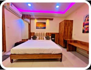 een slaapkamer met een bed en paarse verlichting bij Hotel Rajmohan Palace,Gwalior in Gwalior