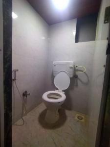 łazienka z białą toaletą w kabinie w obiekcie DC Dormitory Asalpha Metro w Bombaju