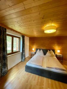 Cama grande en habitación con techo de madera en Untergrübelhof, en Breitenbach am Inn