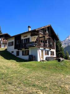 a house on top of a hill with a grass field at Chalet Bergdohle in Rosswald