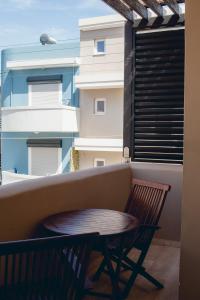 a table and a chair on a balcony at Corinna Mare in Kalamaki Chanion