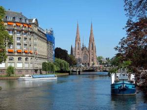 un barco en un río en una ciudad con edificios en Armée 11 - Joli Studio récemment rénové, en Estrasburgo