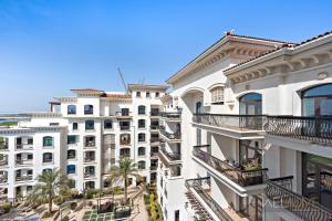 un edificio de apartamentos con balcones y palmeras en WelHome - Luxury Apt Close to Yas Water and Ferrari World, en Abu Dabi