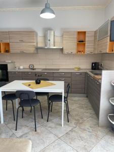 cocina con mesa blanca y sillas en Appartament casa dei limoni, en Catania